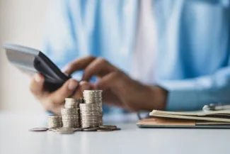 Businessman using calculator calculating income and expenditure