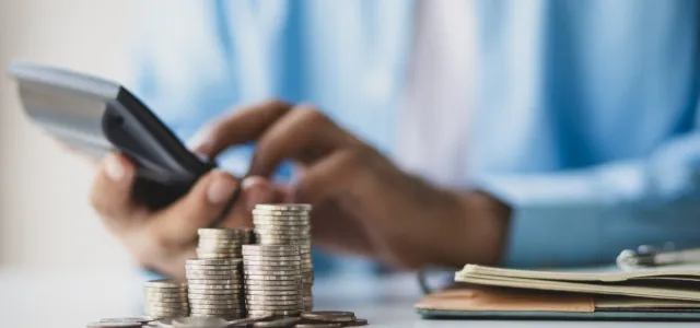 Businessman using calculator calculating income and expenditure